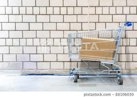 shopping cart with boxes in front of brick wall shopping cart with boxes in front of brick wall 88106030