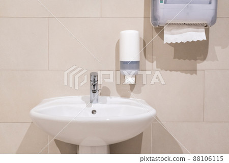 Sink next to soap dispenser pump and paper towel dispenser Sink next to soap dispenser pump and paper towel dispenser 88106115