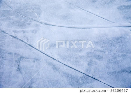 Ice background with marks from skating and hockey, blue texture of rink surface with many scratches Ice background with marks from skating and hockey, blue texture of rink surface with many scratches 88106457