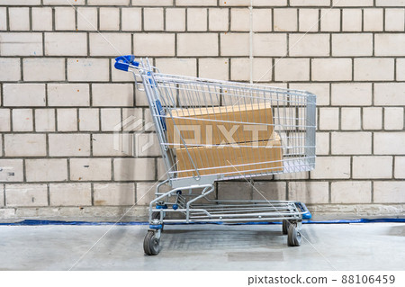 shopping cart with boxes in front of brick wall shopping cart with boxes in front of brick wall 88106459