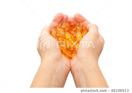 hands holding omega-3 fish fat oil capsules 88106913
