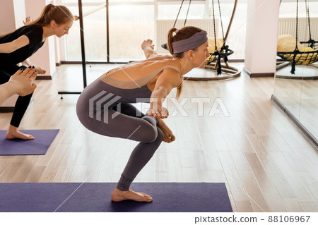 Women exercising in fitness studio yoga classes, sport and health concept Women exercising in fitness studio yoga classes, sport and health concept 88106967