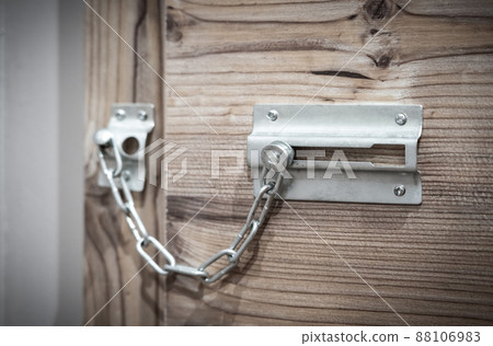 Metal security door chain on wooden door 88106983