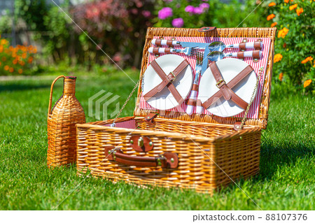 Picnic Wicker basket on green sunny lawn in the park 88107376