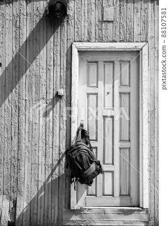 Backpack hanging on a wooden vintage door Backpack hanging on a wooden vintage door 88107581