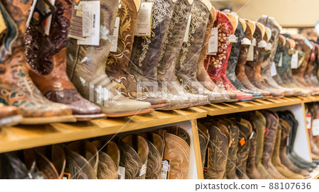 LOS ANGELES, CALIFORNIA, USA - MAY 20, 2015 - Close-up of new cowboy boots on shelf in Boot Barn store LOS ANGELES, CALIFORNIA, USA - MAY 20, 2015 - Close-up of new cowboy boots on shelf in Boot Barn store 88107636