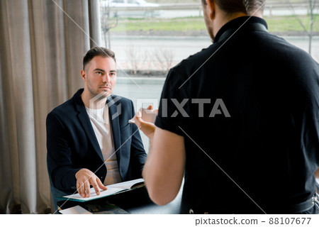 Young man with menu in a restaurant making order 88107677