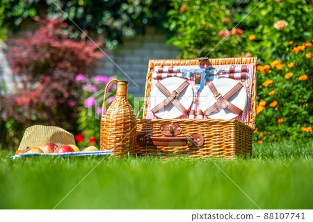 Picnic basket on green sunny lawn in the park Picnic basket on green sunny lawn in the park 88107741