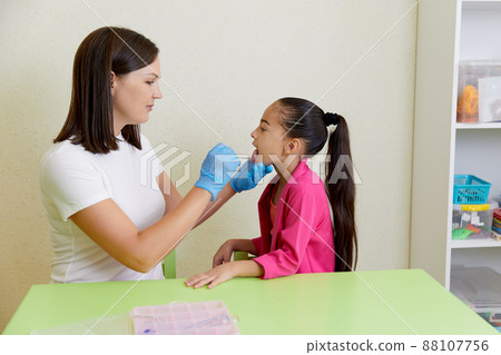 Speech therapist working with girl training pronunciation Speech therapist working with girl training pronunciation 88107756