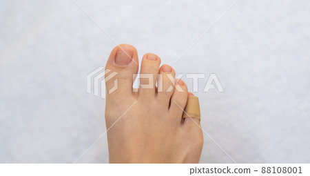 Medical plaster on the female little toe. Wound at toe healed with a band aid for medical care Medical plaster on the female little toe. Wound at toe healed with a band aid for medical care 88108001