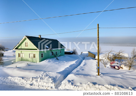 Green country house in winter Russian village surrounded by snowdrifts, Republic of Karelia. 88108613