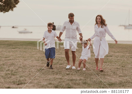 Senior couple in casual clothes with their children, boy and girl enjoy the beach spending a vacation together. Family time . Selective focus Senior couple in casual clothes with their children, boy and girl enjoy the beach spending a vacation together. Family time . Selective focus 88110177