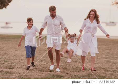 Senior couple in casual clothes with their children, boy and girl enjoy the beach spending a vacation together. Family time . Selective focus Senior couple in casual clothes with their children, boy and girl enjoy the beach spending a vacation together. Family time . Selective focus 88110182