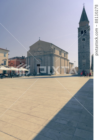 Umag town in Croatia, main square with church and tower at dusk 88110278