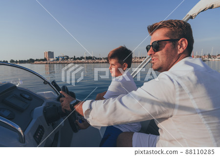 Father and son enjoy their vacation together while riding a luxury boat at sea. Selective focus Father and son enjoy their vacation together while riding a luxury boat at sea. Selective focus 88110285