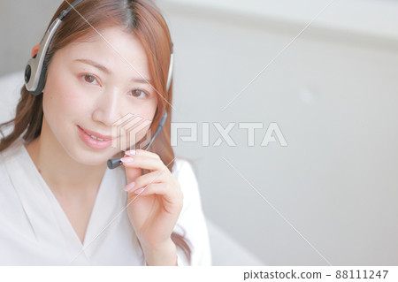 Smiling operator holding a headset_close-up 6 Smiling operator holding a headset_close-up 6 88111247