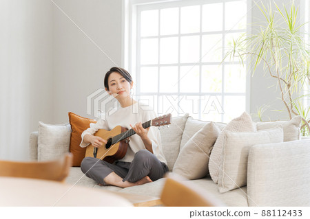 A woman playing the guitar A woman playing the guitar 88112433