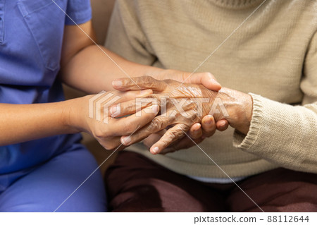 Caregiver massaging finger of elderly woman in painful swollen gout . Caregiver massaging finger of elderly woman in painful swollen gout . 88112644