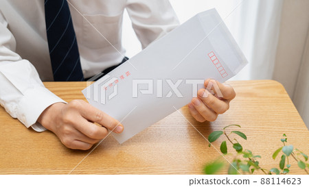 A man in a suit and a red-inked envelope containing a resume | Image of job hunting and career change 88114623