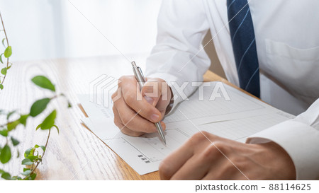 A man in a suit writing a resume │ Job hunting / job hunting image 88114625