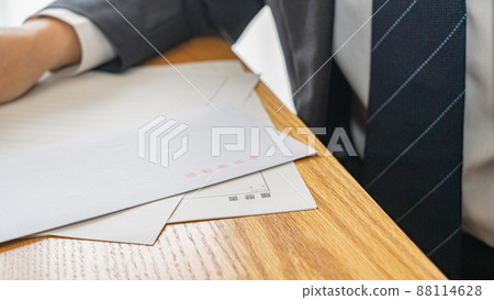 A man in a suit with a resume and a red-lettered envelope | Image of job hunting and career change A man in a suit with a resume and a red-lettered envelope | Image of job hunting and career change 88114628