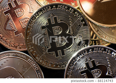 Horizontal view of cryptocurrency tokens, including Bitcoin, dogecoin, and ethererum seen from above on a black background 88114743