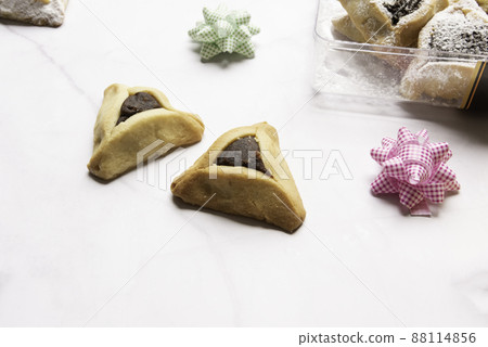 Purim celebration concept, jewish carnival holiday. Traditional hamantaschen cookies over white wooden table 88114856