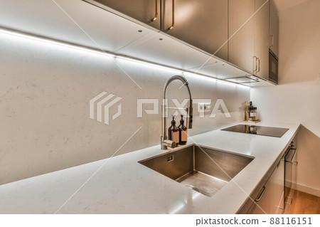 The interior of the corner kitchen of a modern house with lots of cabinets 88116151