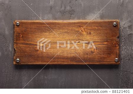 Wooden nameplate or sign board screwed at wall background. Front view of name plate Wooden nameplate or sign board screwed at wall background. Front view of name plate 88121401