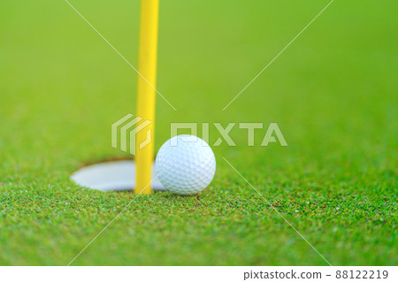 Golf ball on lip of cup at golf court Golf ball on lip of cup at golf court 88122219