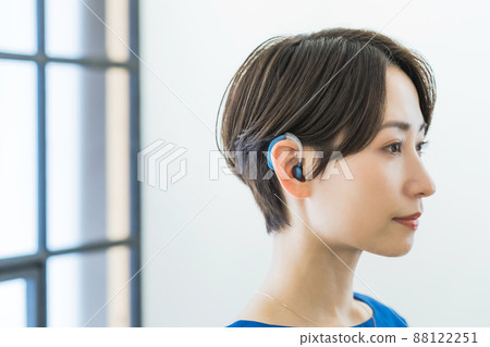 Woman wearing a hearing aid Woman wearing a hearing aid 88122251