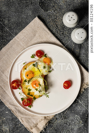Fried eggs on toast, cherry tomatoes and arugula microgreens. Delicious and healthy breakfast recipe. Top view. Copy space 88124196