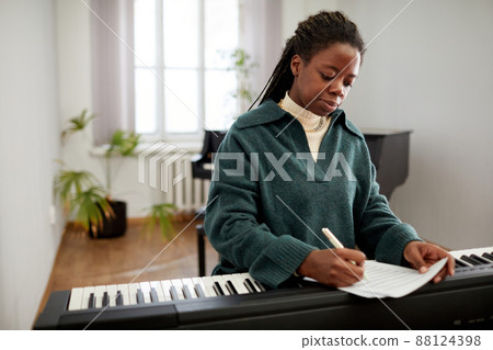 Woman composing the music on synthesizer 88124398