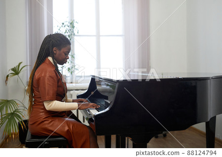 Woman performing on grand piano Woman performing on grand piano 88124794