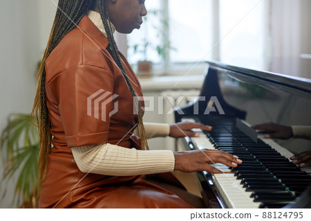 Woman learning to play the piano Woman learning to play the piano 88124795