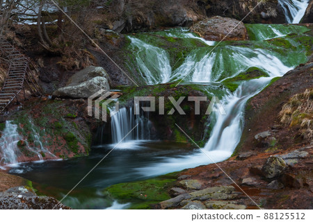 Underground water flowing over green moss and red rocks Underground water flowing over green moss and red rocks 88125512