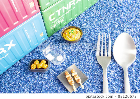 Miniatures of various chicken dishes placed in containers on a blue towel next to spoons and forks 88126672