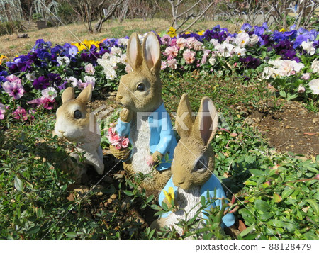 Garden ornament rabbits and flowers in a flowerbed Garden ornament rabbits and flowers in a flowerbed 88128479