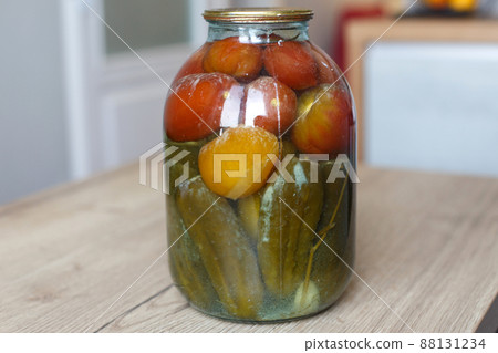 spoiled can of vegetable seaming. Glass jar with homemade pickled tomatos and cucumbers with white fungus spoiled can of vegetable seaming. Glass jar with homemade pickled tomatos and cucumbers with white fungus 88131234