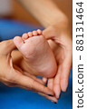 Hands of mother in the form of a heart on children's legs 88131464