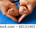 Hands of mother in the form of a heart on children's legs 88131465