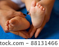 Hands of mother in the form of a heart on children's legs 88131466