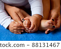 Hands of mother in the form of a heart on children's legs 88131467