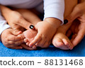 Hands of mother in the form of a heart on children's legs 88131468