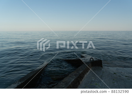 Sea waves run into a concrete pier. Night sea. 88132590