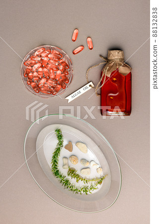 Glass bottle with algae oil, live seaweed and jelatin capsules on brown paper Glass bottle with algae oil, live seaweed and jelatin capsules on brown paper 88132838