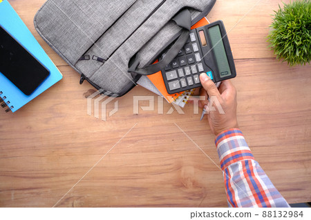top view of young man putting office stationary in his bag top view of young man putting office stationary in his bag 88132984