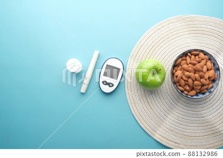 diabetic measurement tools, almond nut and apple on table  88132986