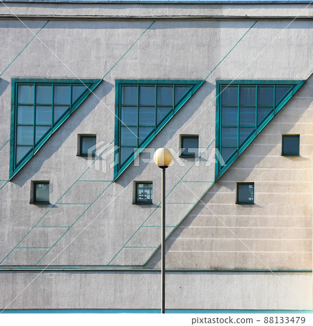 Windows in triangle shape on facade of modern building. 88133479