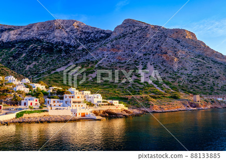 Beautiful view of Mediterranean island at sunset. Small Greek fisherman village in rays of low sun. Sun flares, whitewashed houses, Milos, Greece. Beautiful view of Mediterranean island at sunset. Small Greek fisherman village in rays of low sun. Sun flares, whitewashed houses, Milos, Greece. 88133885